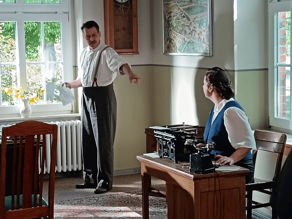 Historische Szene im Büro mit Mann und Frau im Vintage-Outfit, Abenteurlicher Arbeitsalltag, Erinnerungen an vergangene Zeiten, authentische Atmosphäre, nostalgisches Ambiente.