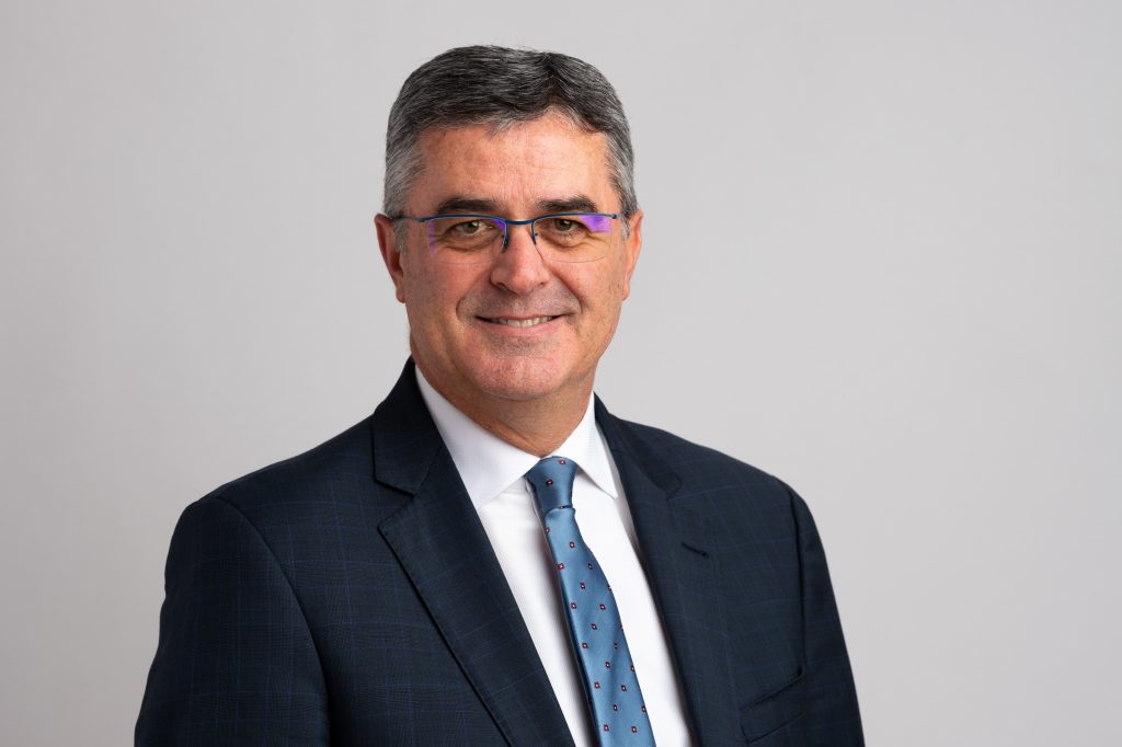 Porträtfoto eines Mannes in formeller Kleidung, der vermutlich für eine professionelle oder kirchliche Publikation auf advent-verlag.de fotografiert wurde.