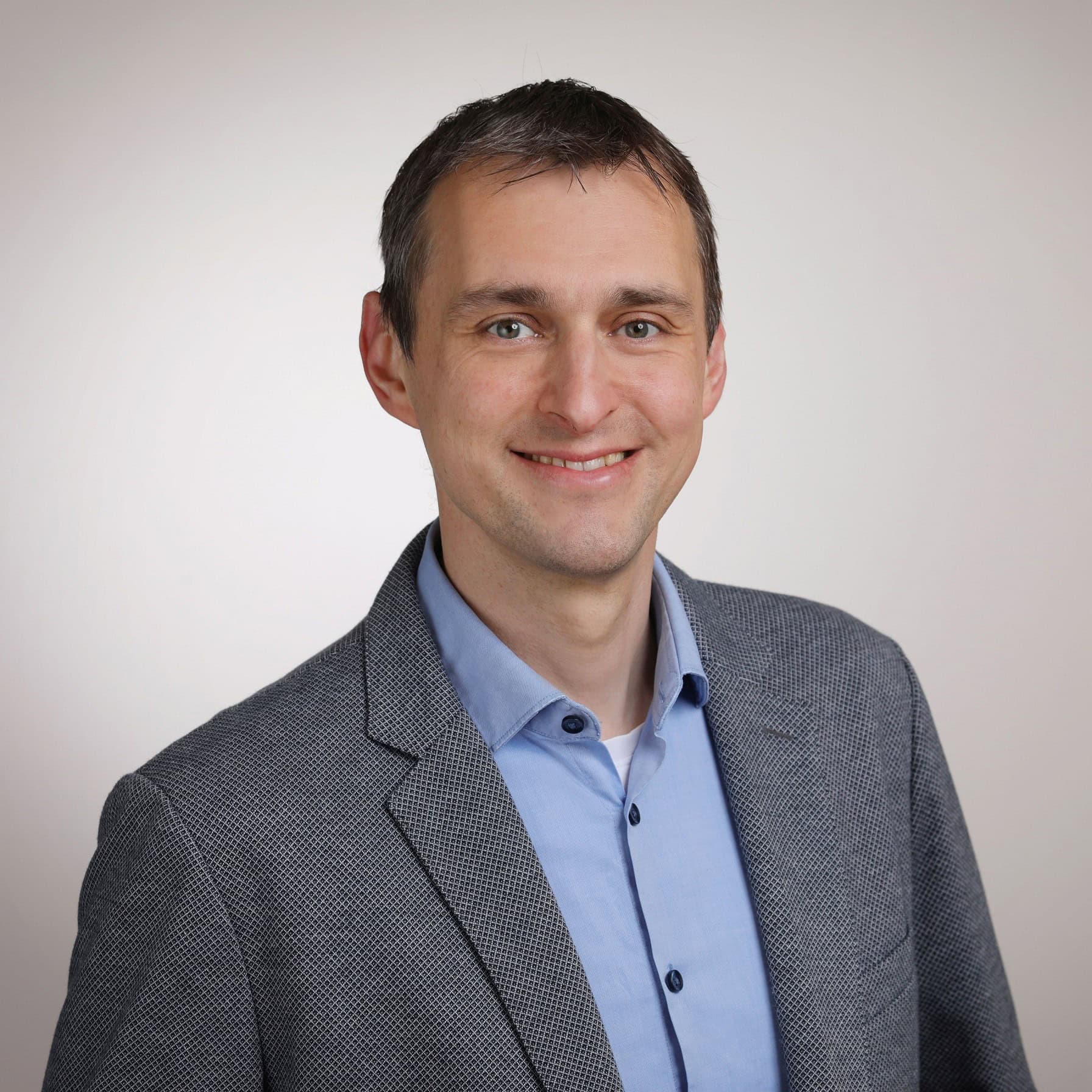 1. Hochwertiges Porträt eines charmanten Mannes in business casual Kleidung vor neutralem Hintergrund, perfekte Darstellung für professionelle Profile und Business-Kommunikation.