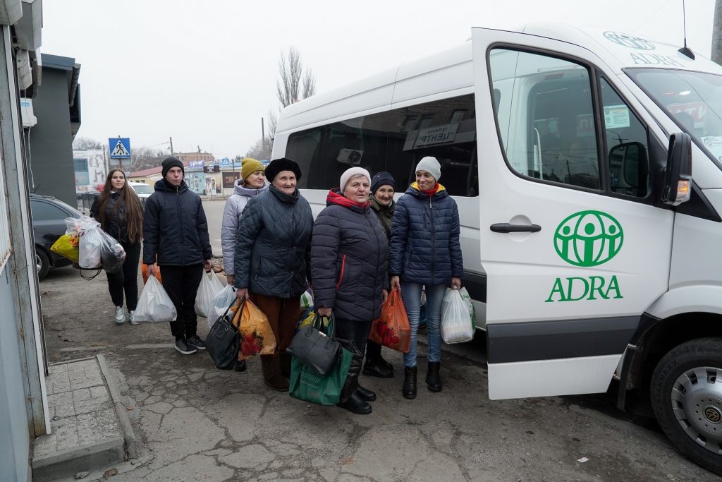 Obdachlose Menschen steigen in einen ADRA-Sammelbus, um Unterstützung und Versorgung zu erhalten.