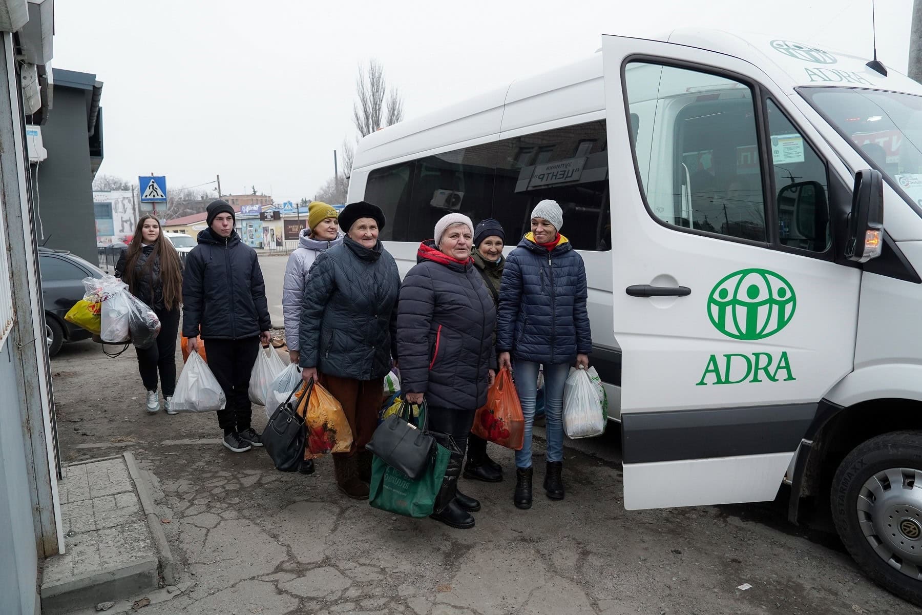 Obdachlose Menschen steigen in einen ADRA-Sammelbus, um Unterstützung und Versorgung zu erhalten.